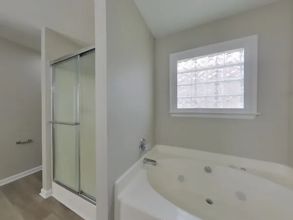a white bath tub sitting in a bathroom next to a window