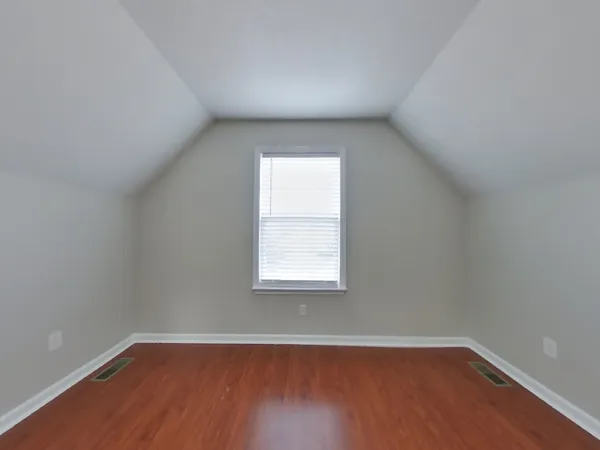 an empty room with wooden closet and windows