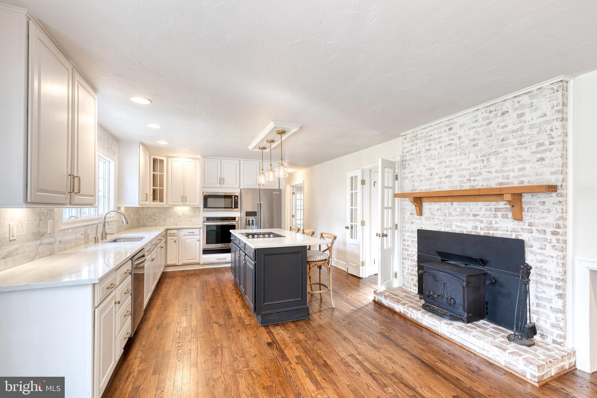 1216 Bonaire Road Forest Hill, MD 21050 - Photo 18 of 71 a large kitchen with stainless steel appliances granite countertop a stove top oven a sink dishwasher and a fireplace with wooden floor