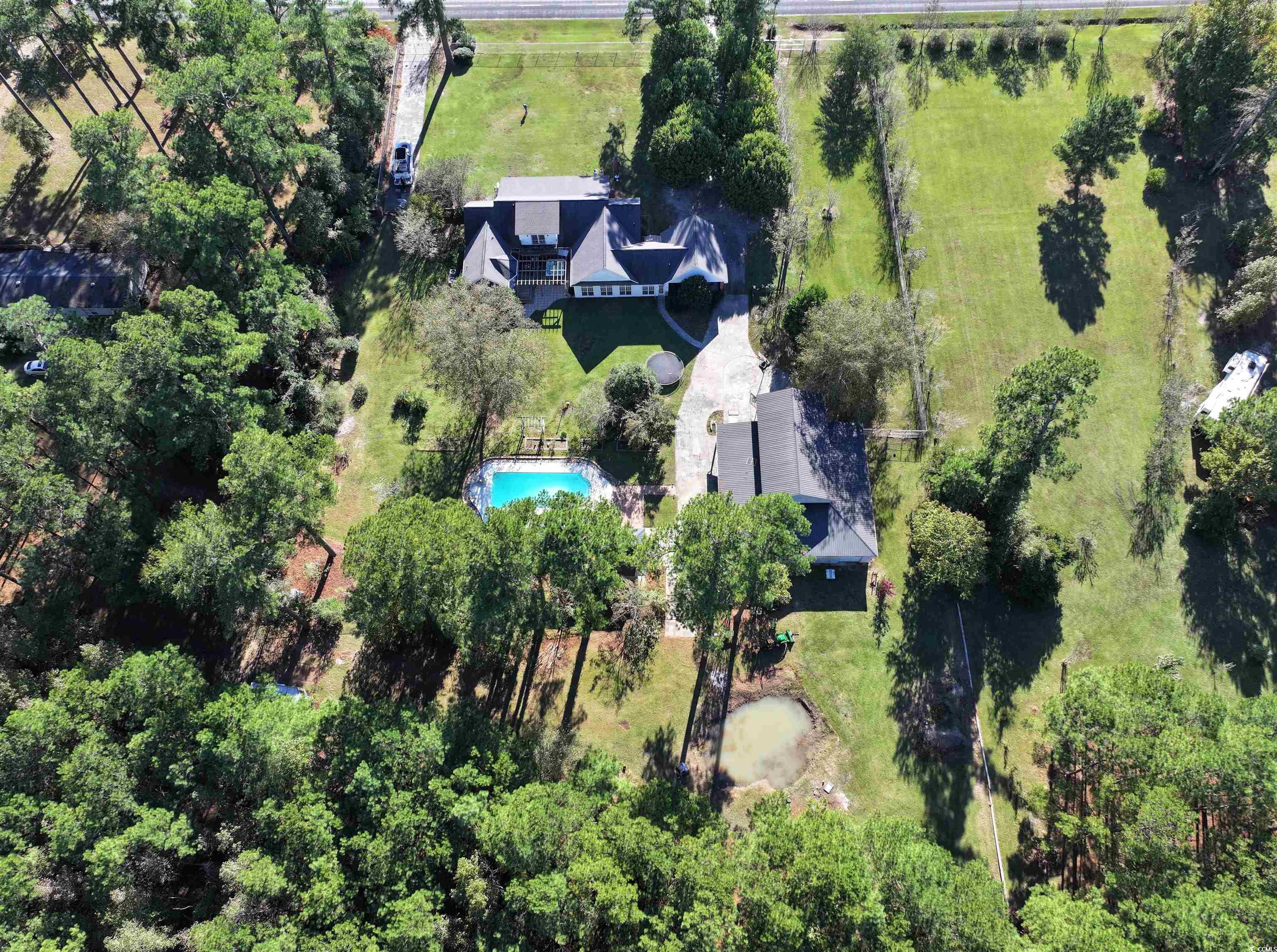 1484 Fitch Road Lake City, SC 29560 - Photo 2 of 40 Aerial view of property and surrounding area featuring a pool, tiki bar, house, and barn