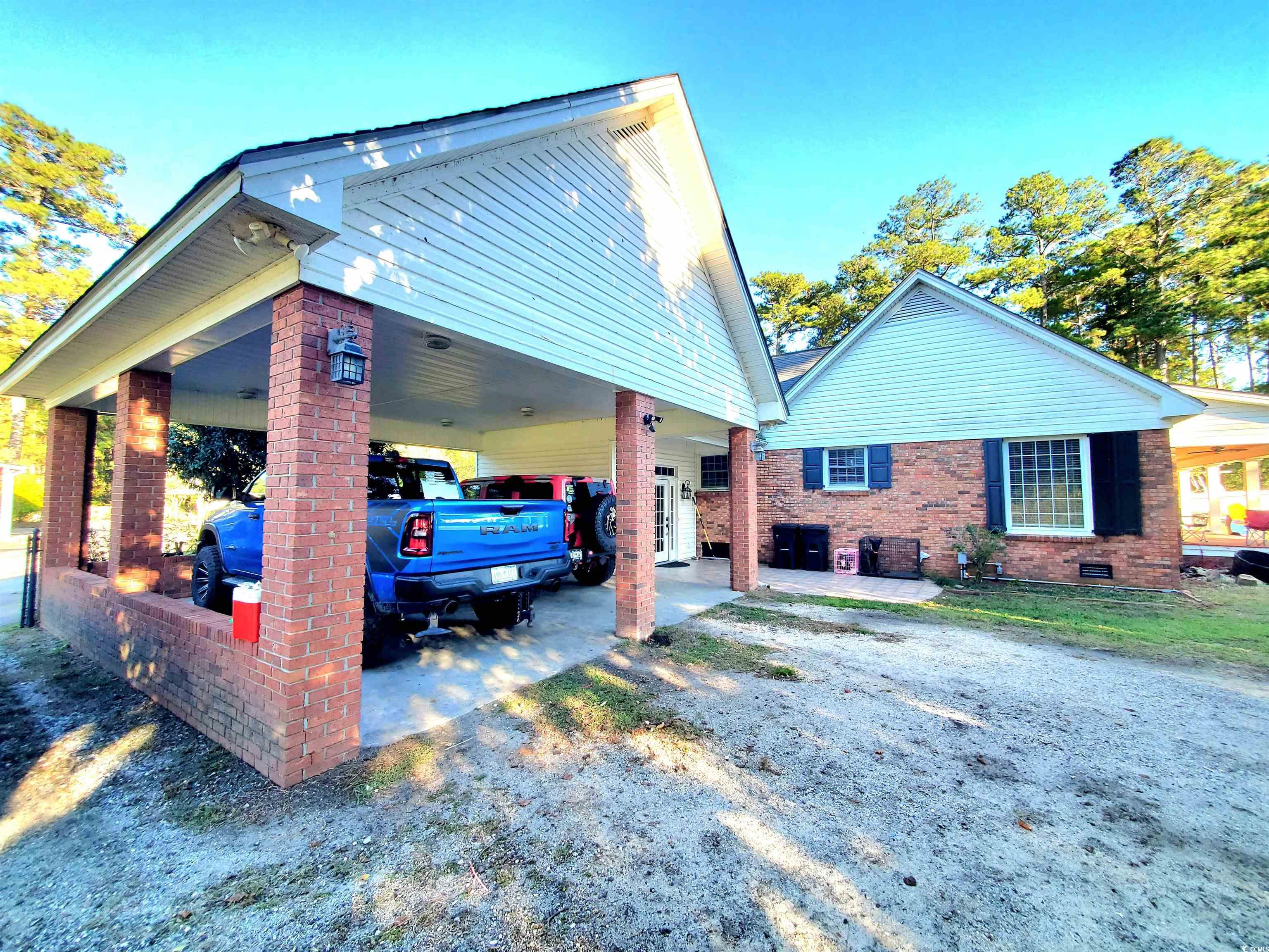1484 Fitch Road Lake City, SC 29560 - Photo 26 of 40 View of home's exterior featuring a patio, brick siding, an attached carport, and crawl space