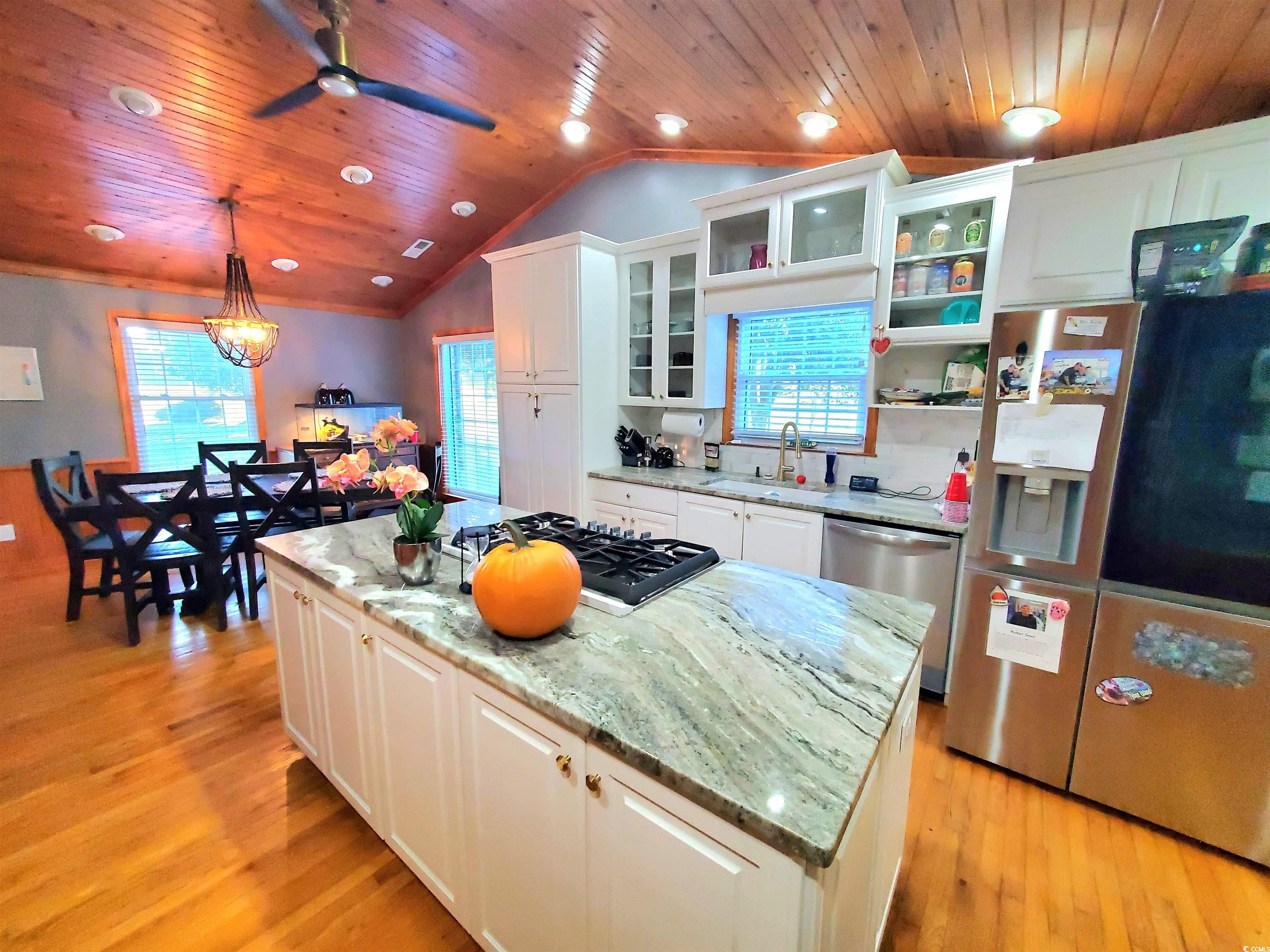 1484 Fitch Road Lake City, SC 29560 - Photo 5 of 40 Kitchen with white cabinetry, light stone counters, stainless steel appliances, hanging light fixtures, and a center island