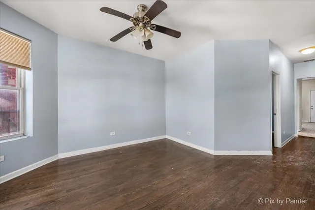 an empty room with wooden floor closet and windows