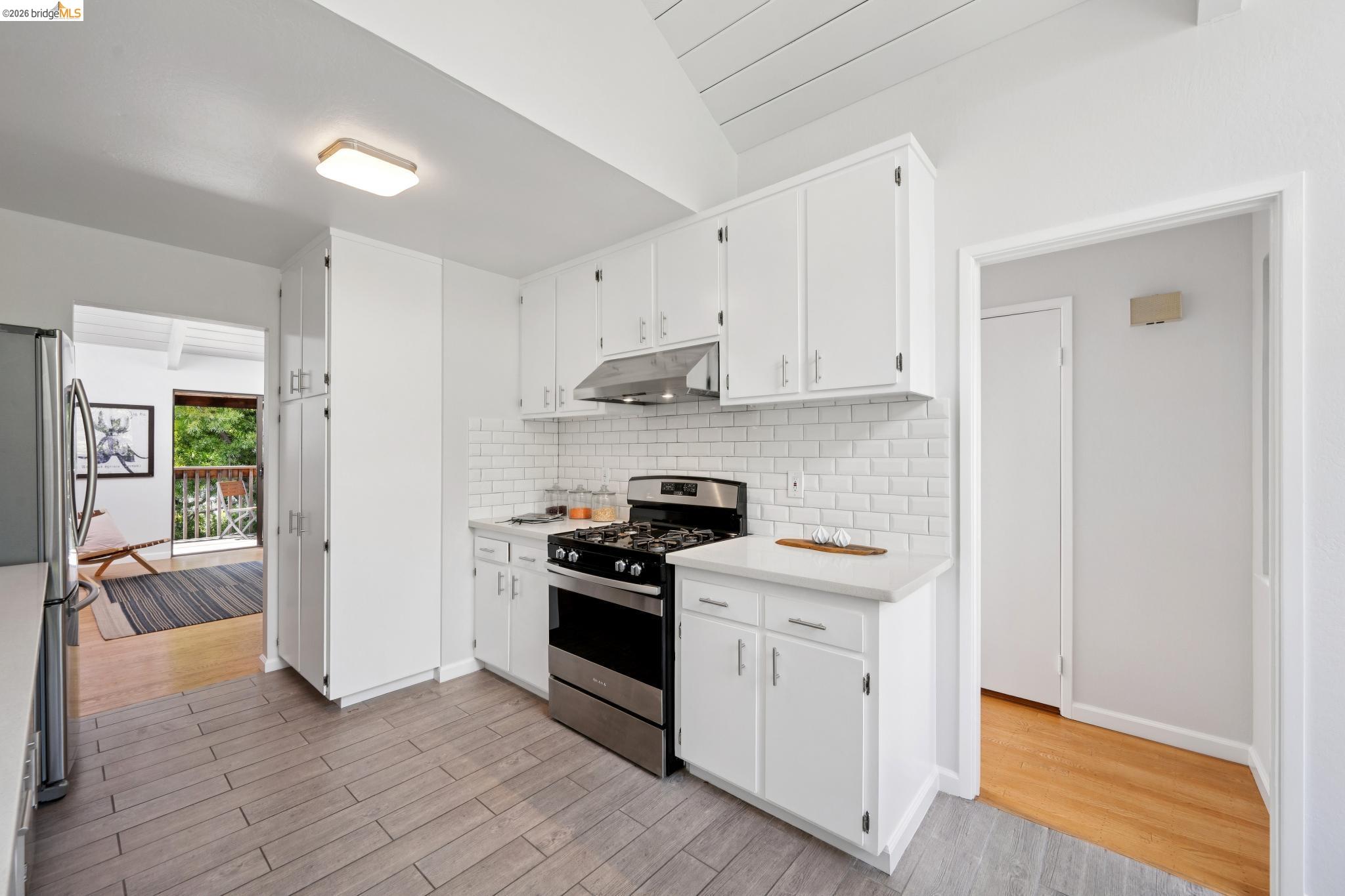 1340 Henry Street Berkeley, CA 94709 - Photo 21 of 52 Kitchen featuring white wood cabinetry, a stainless steel gas range, white subway tile backsplash, and light-colored countertops