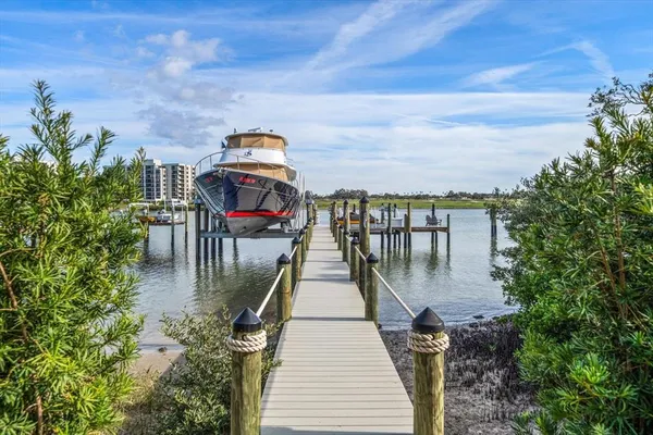 a kitchen with stainless steel appliances granite countertop a stove top oven a sink dishwasher a dining table and chairs with wooden floor