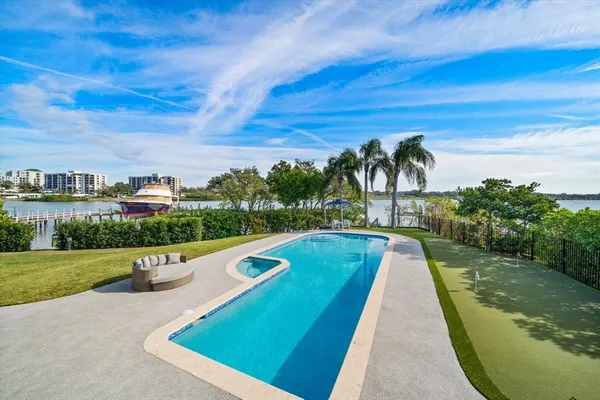 a large kitchen with a large counter space a sink stainless steel appliances and cabinets