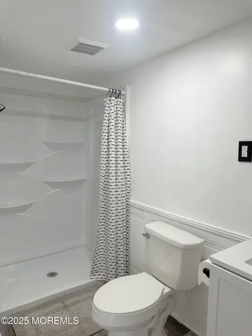 a white toilet sitting next to a shower