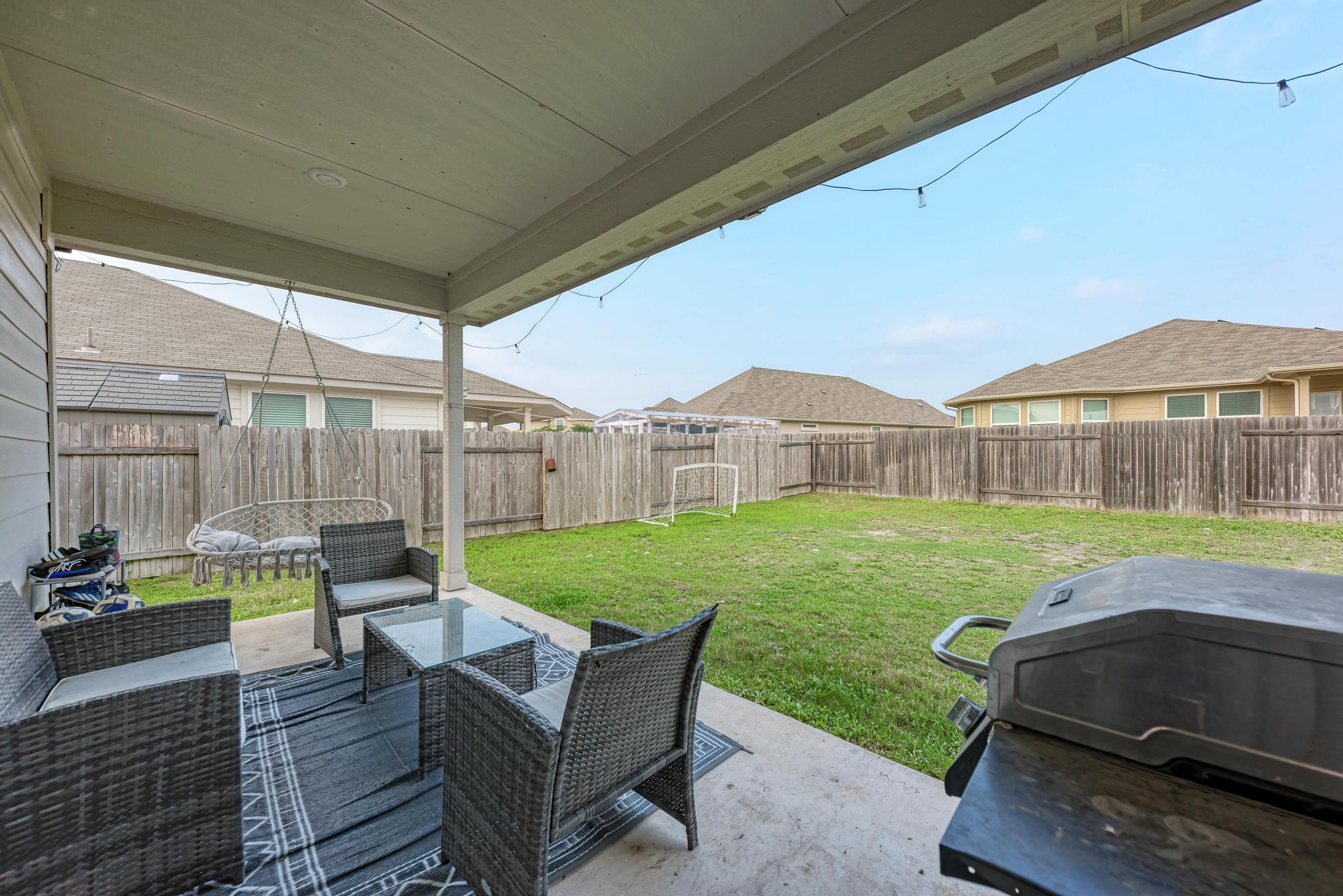 305 Windy Reed Road Hutto, TX 78634 - Photo 27 of 35 An inviting covered patio overlooks a fully fenced backyard with plenty of green lawn.
