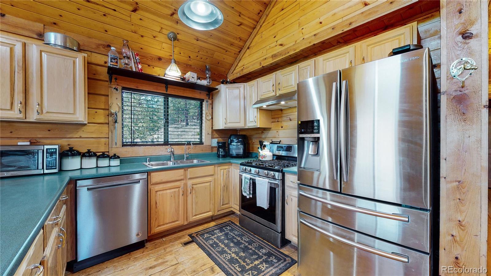 688 Beartrap Road Red Feather Lakes, CO 80545 - Photo 13 of 40 a kitchen with stainless steel appliances a refrigerator and a sink
