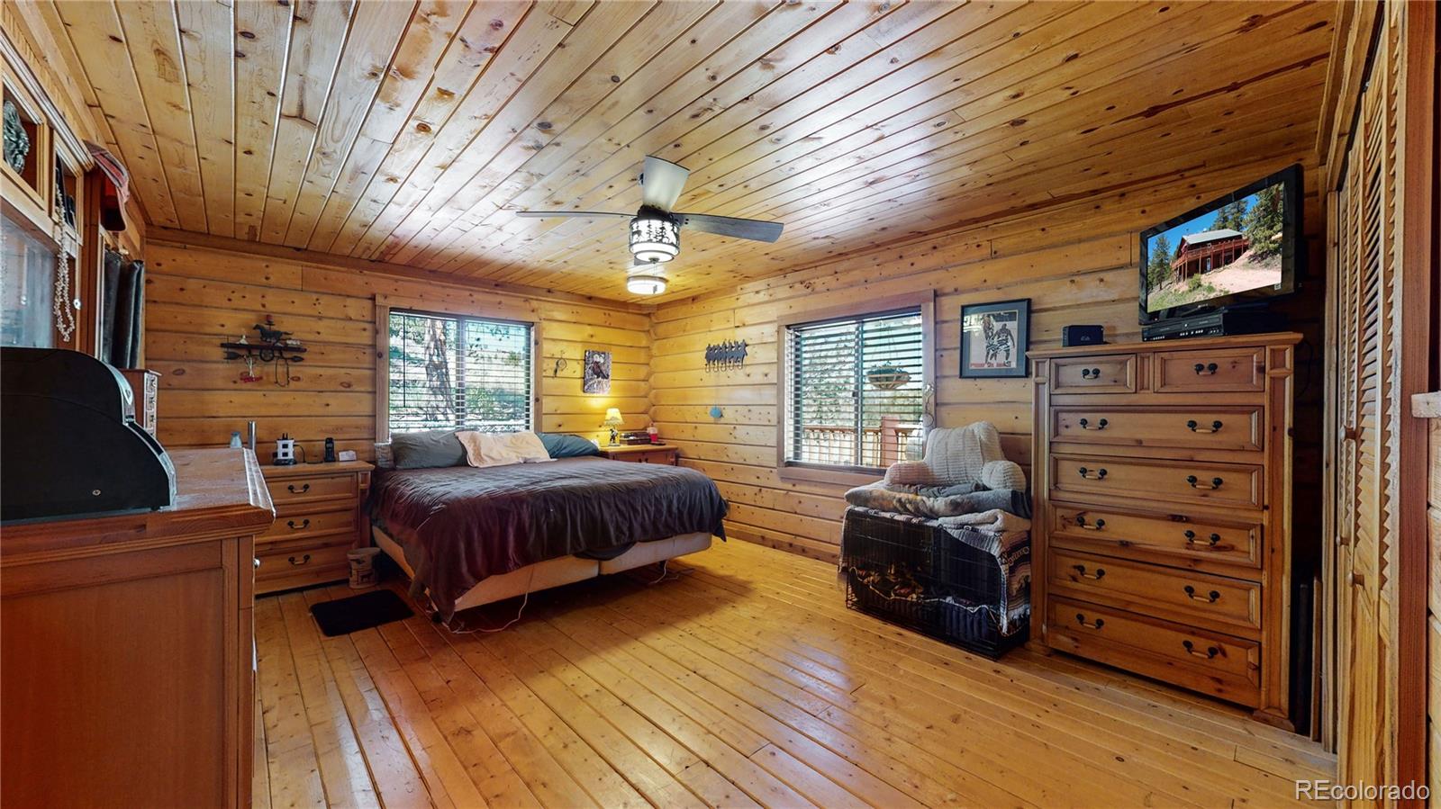 688 Beartrap Road Red Feather Lakes, CO 80545 - Photo 14 of 40 a spacious bedroom with a bed and wooden floor