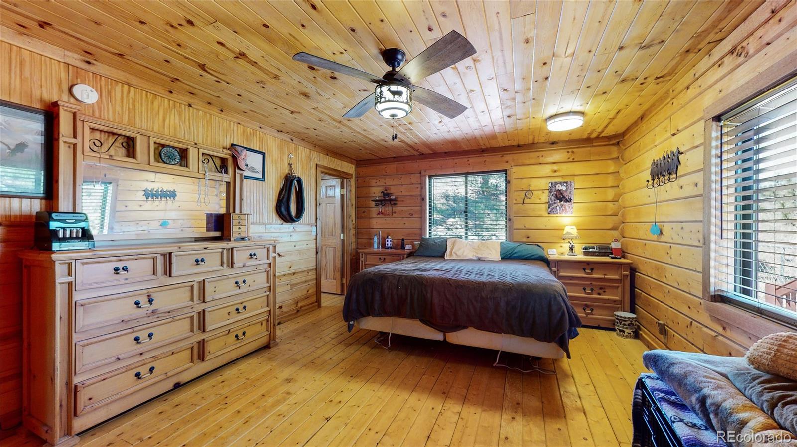 688 Beartrap Road Red Feather Lakes, CO 80545 - Photo 15 of 40 a bedroom with a bed dresser and a window