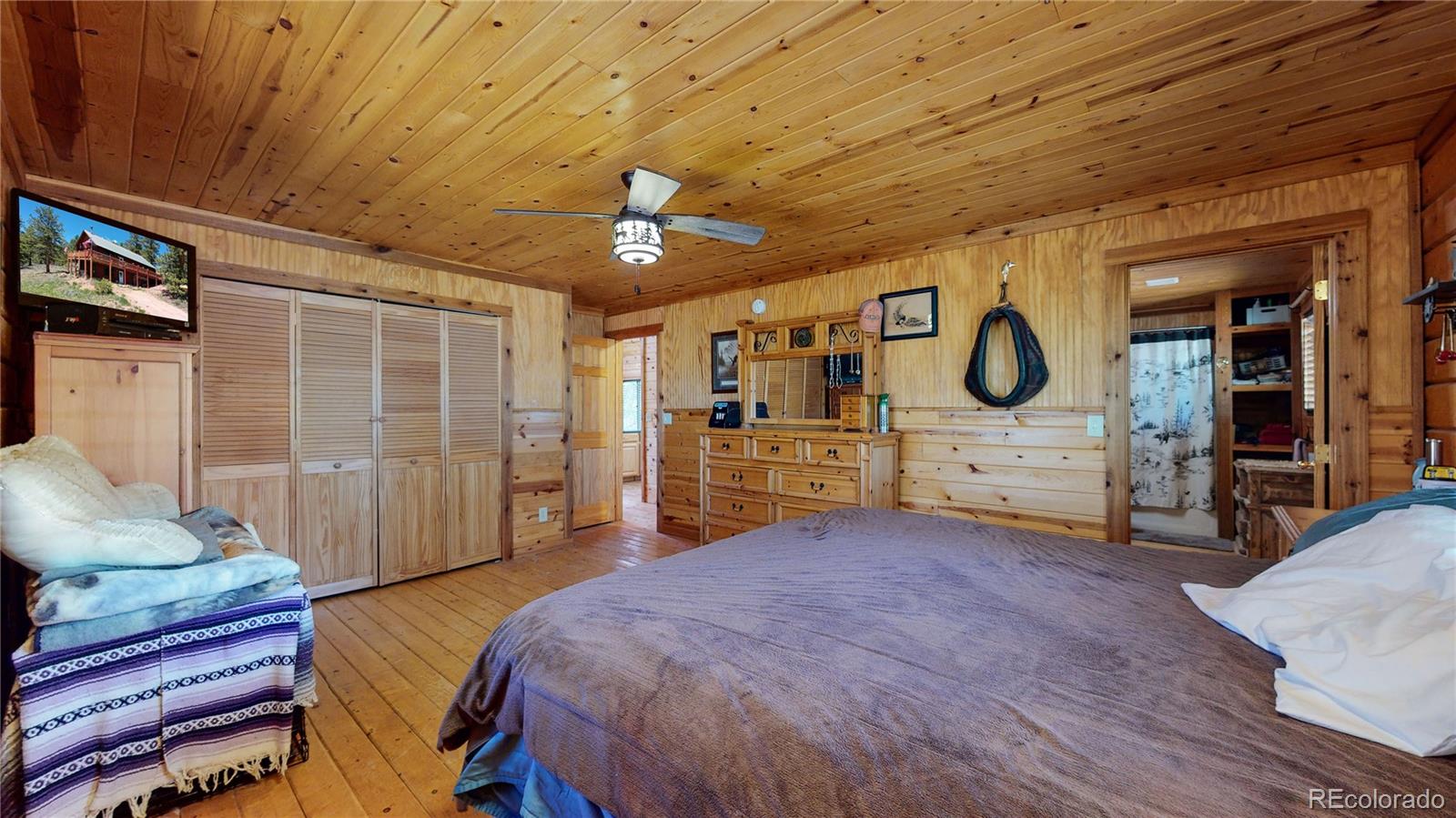 688 Beartrap Road Red Feather Lakes, CO 80545 - Photo 16 of 40 a bed room with a bed and mirror