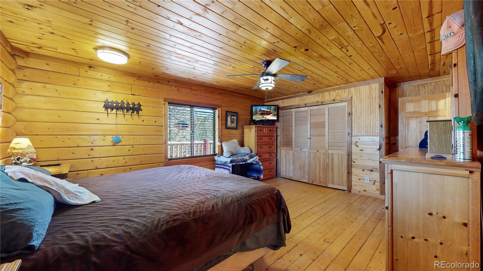 688 Beartrap Road Red Feather Lakes, CO 80545 - Photo 17 of 40 a bed sitting in a bedroom next to a window