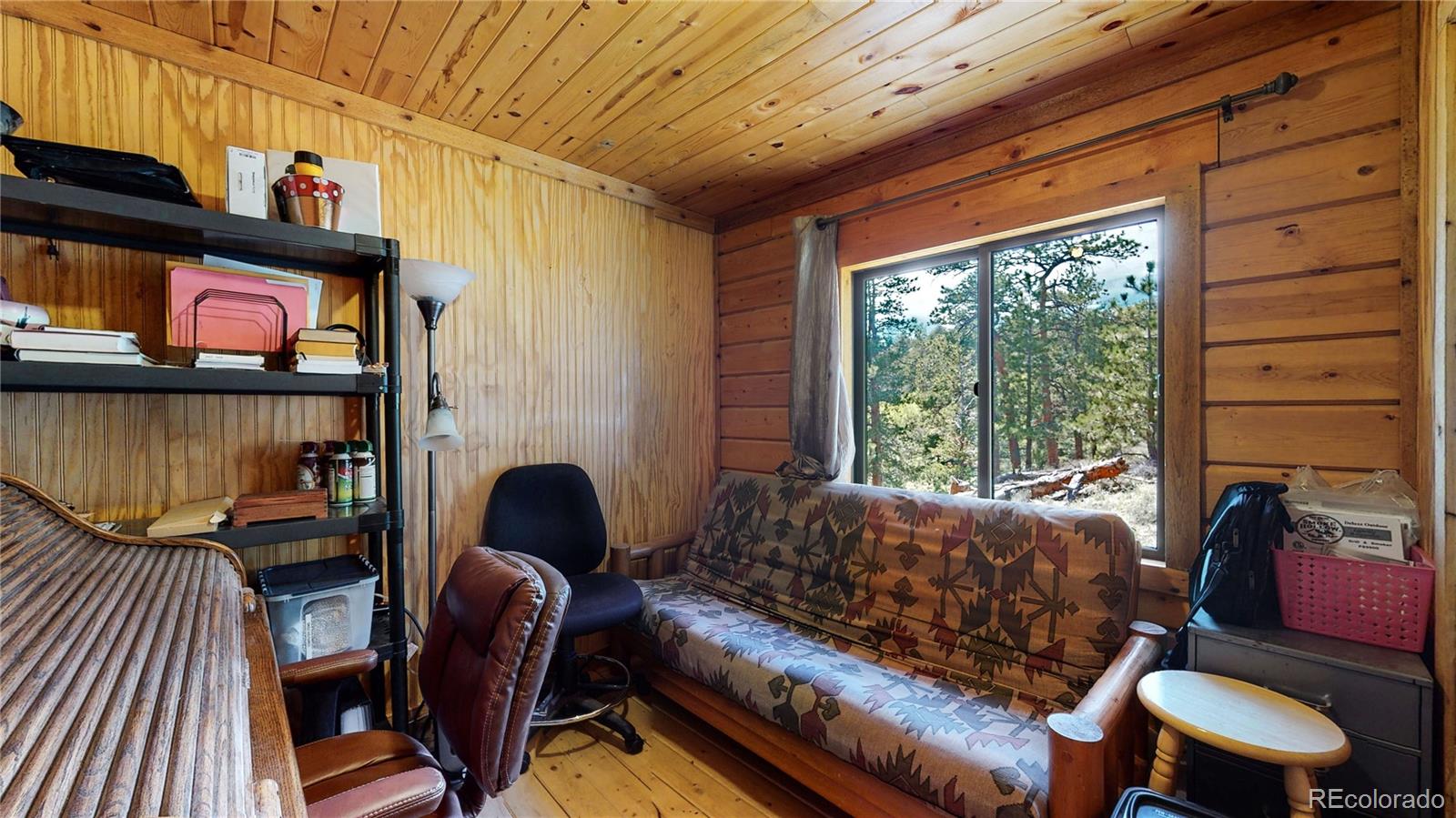 688 Beartrap Road Red Feather Lakes, CO 80545 - Photo 20 of 40 a living room with furniture and a fireplace