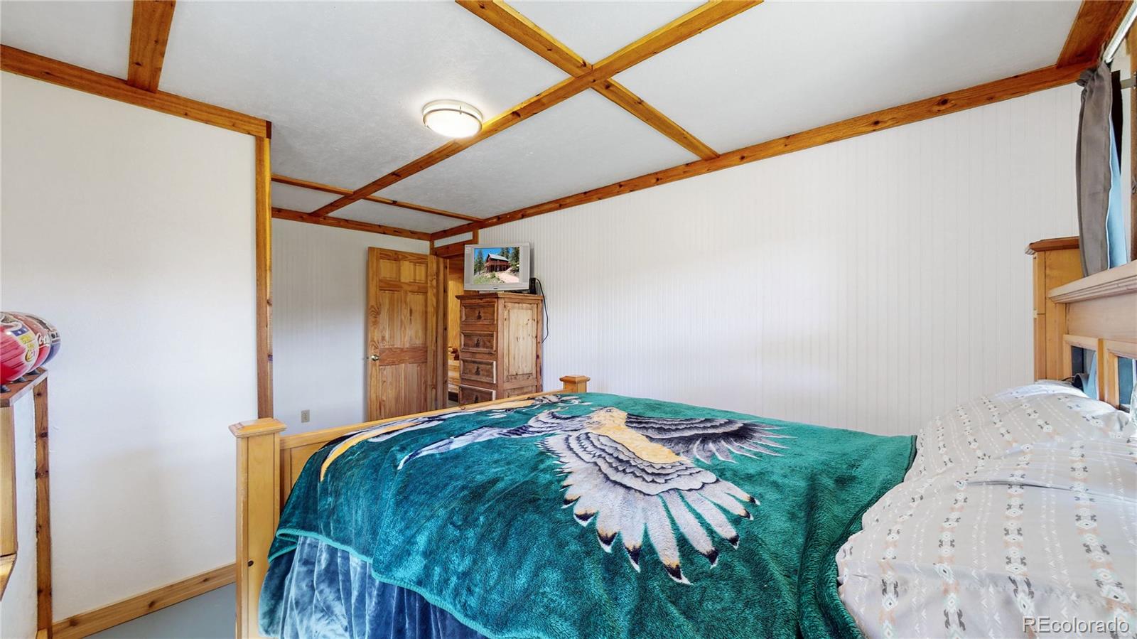 688 Beartrap Road Red Feather Lakes, CO 80545 - Photo 26 of 40 a bedroom with a bed and a mirror