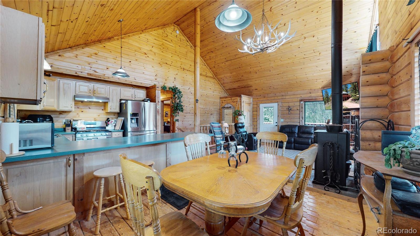 688 Beartrap Road Red Feather Lakes, CO 80545 - Photo 10 of 40 a view of a dining room with furniture and chandelier