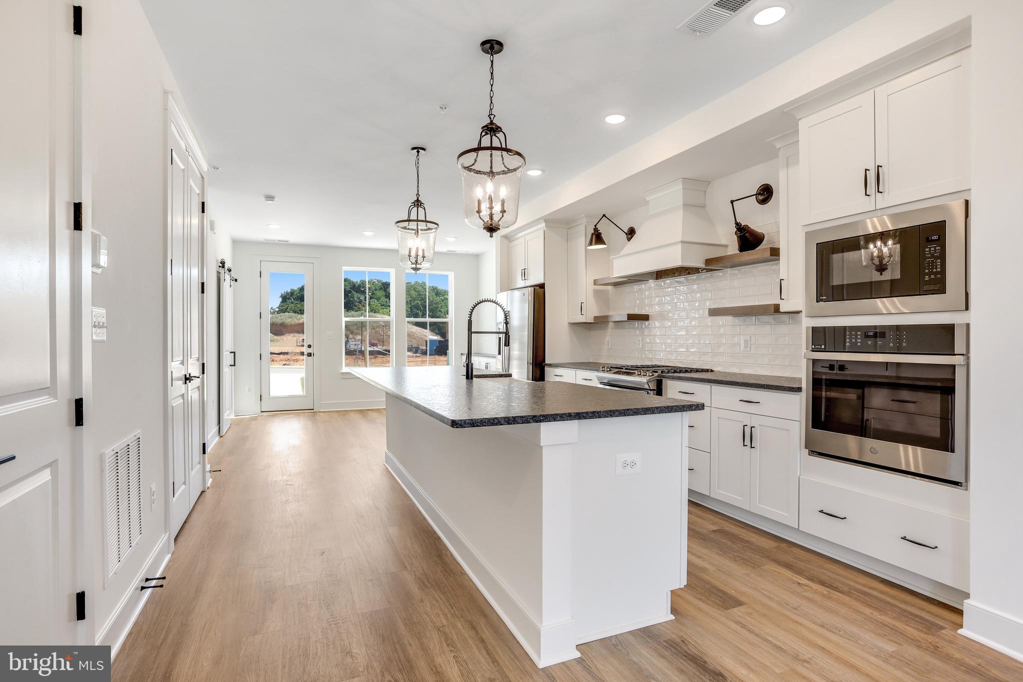 1803 Shookstown Road Frederick, MD 21702 - Photo 6 of 35 a kitchen with stainless steel appliances kitchen island granite countertop a stove a sink and a refrigerator