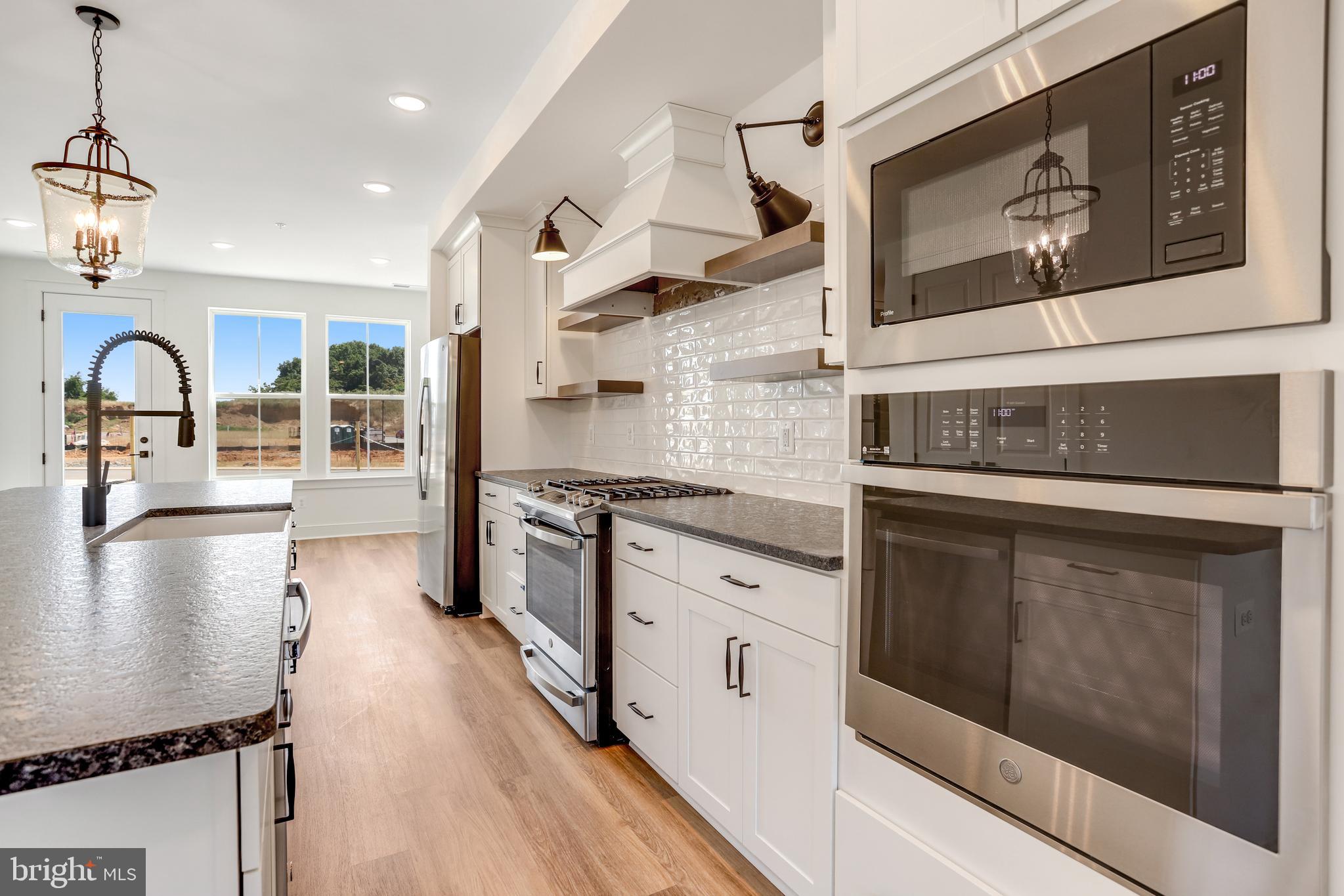 1803 Shookstown Road Frederick, MD 21702 - Photo 8 of 35 a kitchen with stainless steel appliances granite countertop a stove top oven a sink a counter space and cabinets