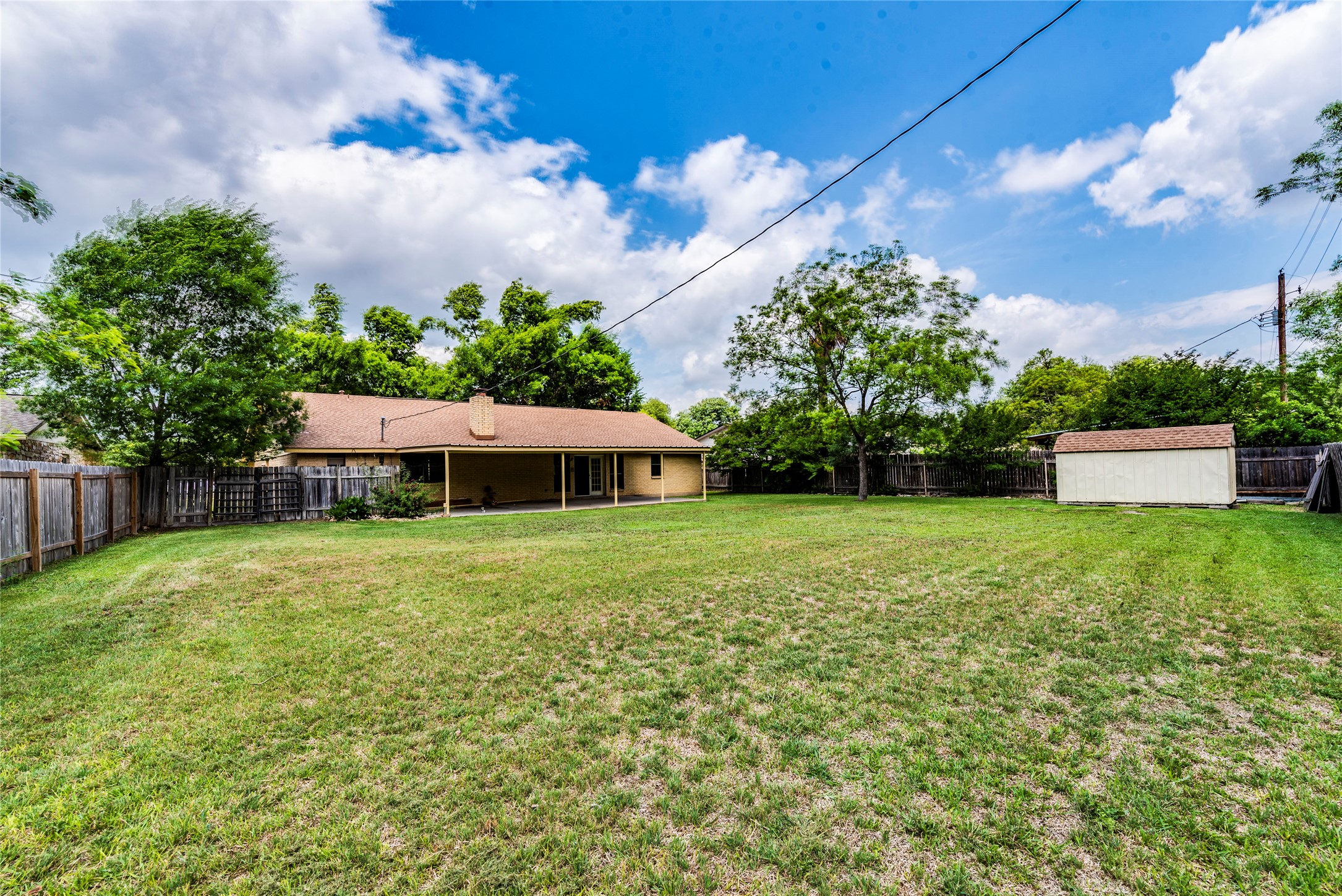 13505 Broadmeade Avenue Austin, TX 78729 - Photo 21 of 21 Fenced backyard with a patio and a storage shed