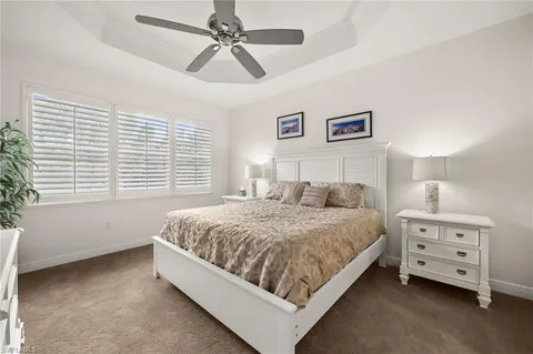 a spacious bedroom with a bed a dresser and a window