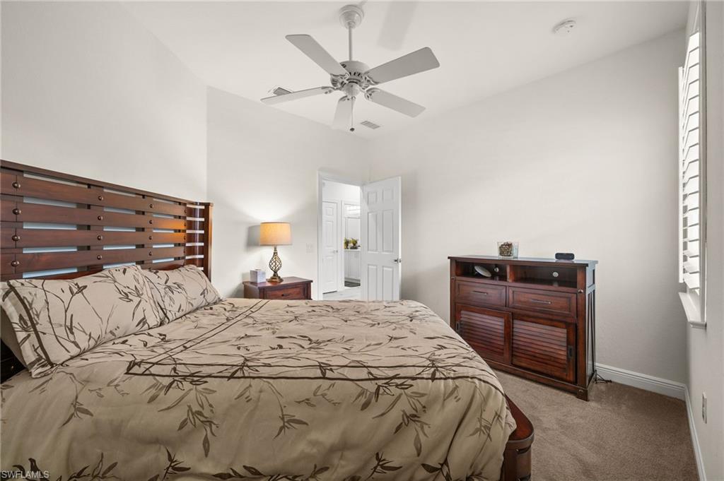 14562 Bellino Terrace, Unit 201 Bonita Springs, FL 34135 - Photo 20 of 46 a bedroom with a bed and a chandelier