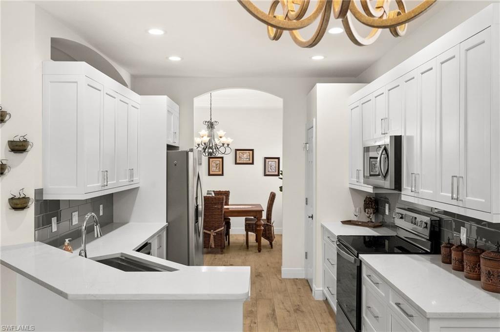 14562 Bellino Terrace, Unit 201 Bonita Springs, FL 34135 - Photo 2 of 46 a kitchen with stainless steel appliances kitchen island granite countertop a sink and cabinets