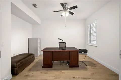 a view of a workspace with furniture and a window