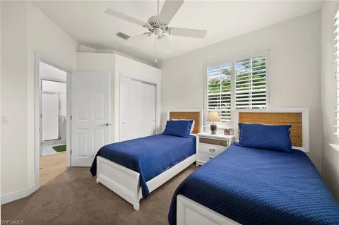 a bedroom with two beds and a chandelier