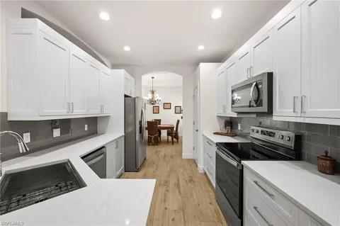 a kitchen with granite countertop a stove sink and cabinets
