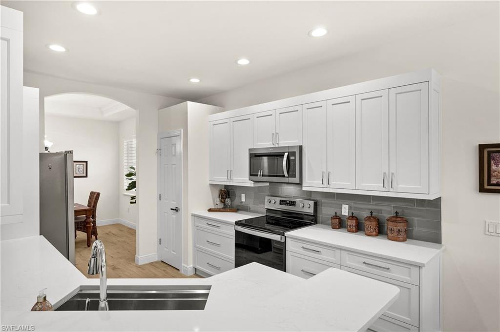 14562 Bellino Terrace, Unit 201 Bonita Springs, FL 34135 - Photo 5 of 46 a kitchen with stainless steel appliances a stove a sink and a refrigerator