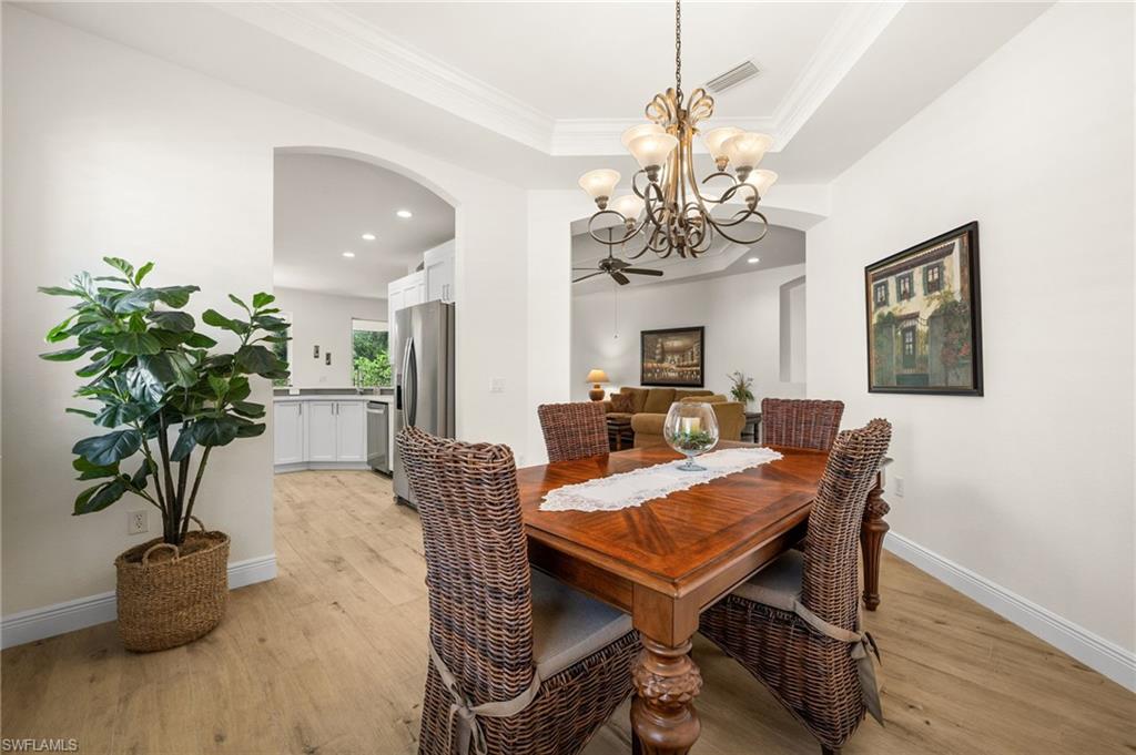 14562 Bellino Terrace, Unit 201 Bonita Springs, FL 34135 - Photo 7 of 46 a living room with furniture a chandelier and a potted plant