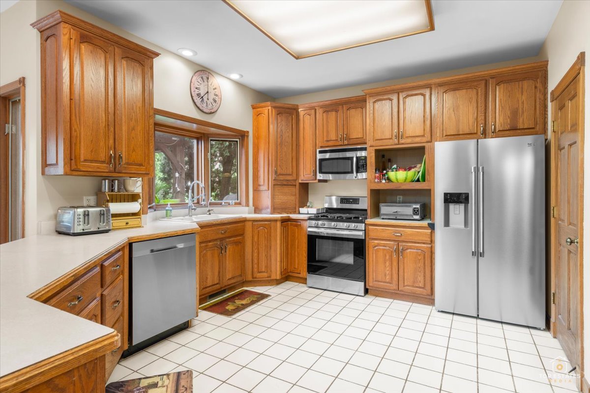 601 Ridgelawn Trail Batavia, IL 60510 - Photo 15 of 57 a kitchen with stainless steel appliances granite countertop a refrigerator a stove top oven and sink