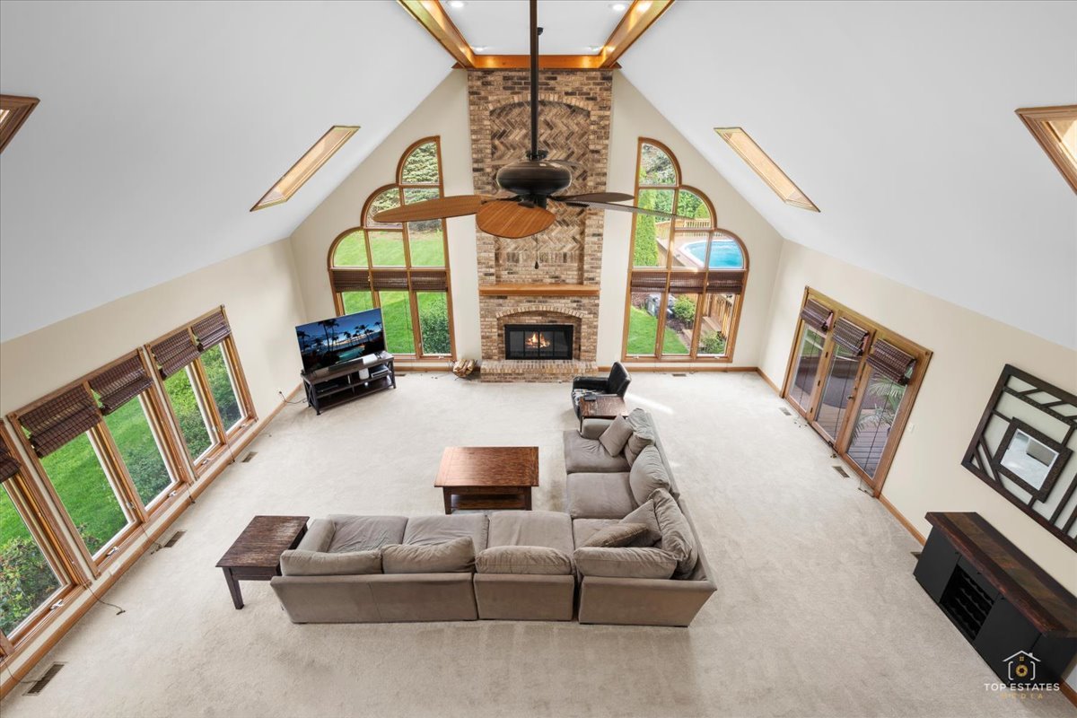 601 Ridgelawn Trail Batavia, IL 60510 - Photo 23 of 57 a living room with furniture a fireplace and a floor to ceiling window