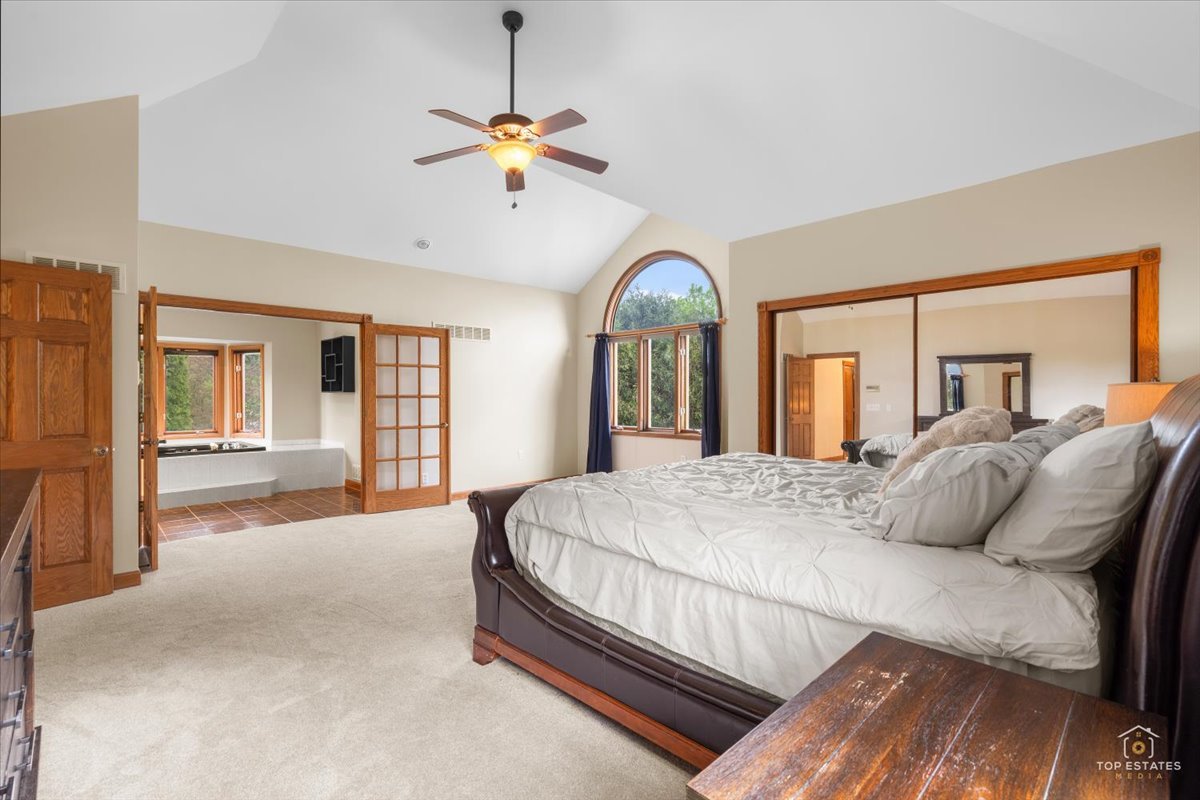 601 Ridgelawn Trail Batavia, IL 60510 - Photo 25 of 57 a bedroom with a large bed and a chandelier