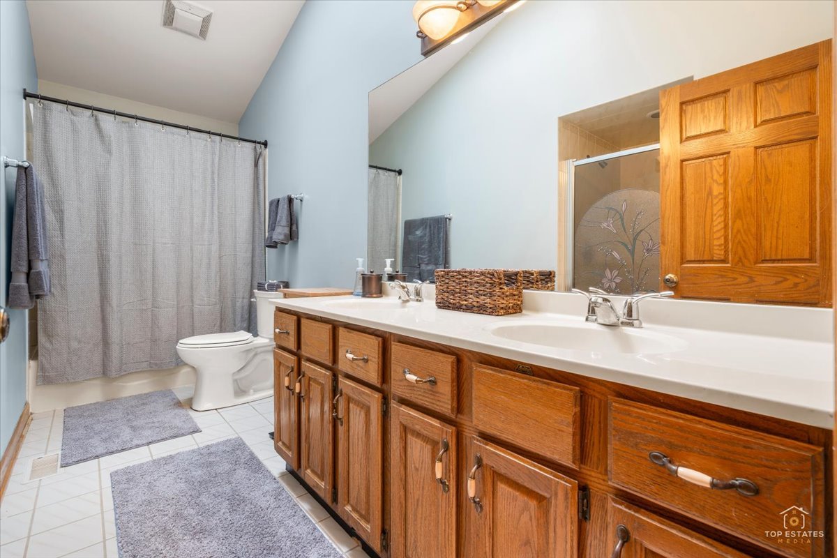 601 Ridgelawn Trail Batavia, IL 60510 - Photo 31 of 57 a bathroom with a double vanity sink toilet and a mirror