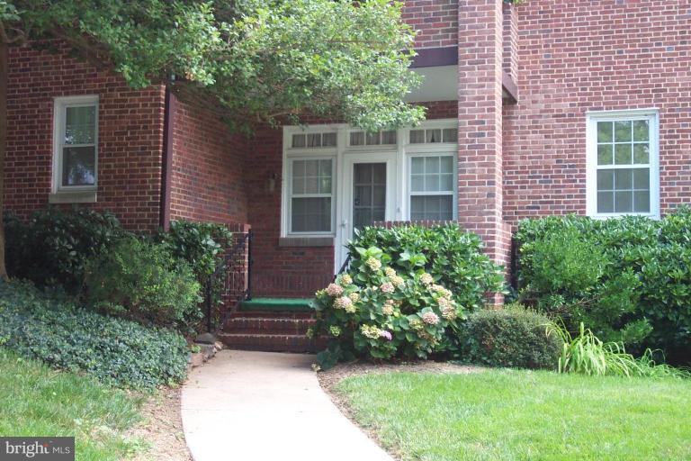 221 Ridgemede Road, Unit 101 Baltimore, MD 21210 - Photo 1 of 1 a view of brick house with a yard and plants