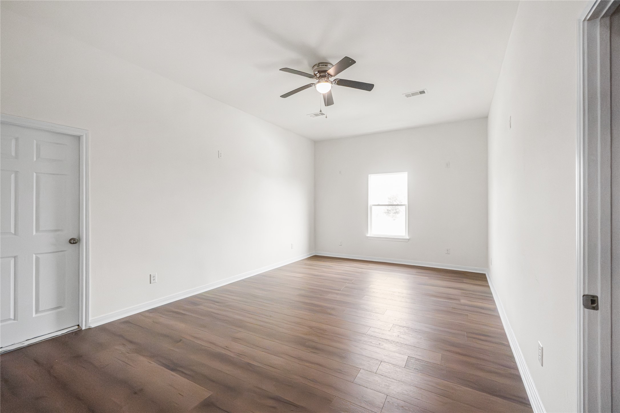 6413 North Ridgecrest Drive Hitchcock, TX 77563 - Photo 22 of 29 an empty room with wooden floor window and ceiling fan
