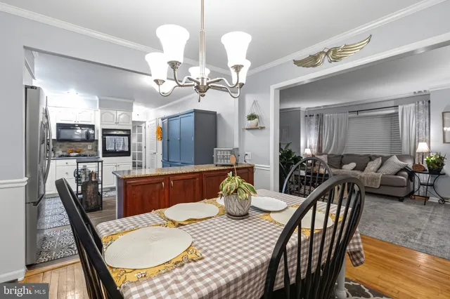 a view of a dining room with furniture a chandelier and wooden floor