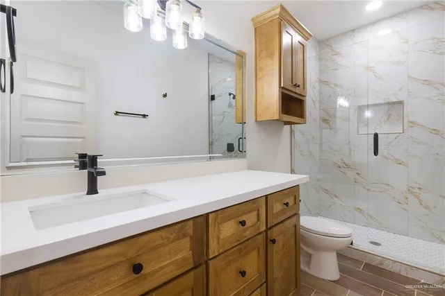 a bathroom with a sink a toilet and a large mirror