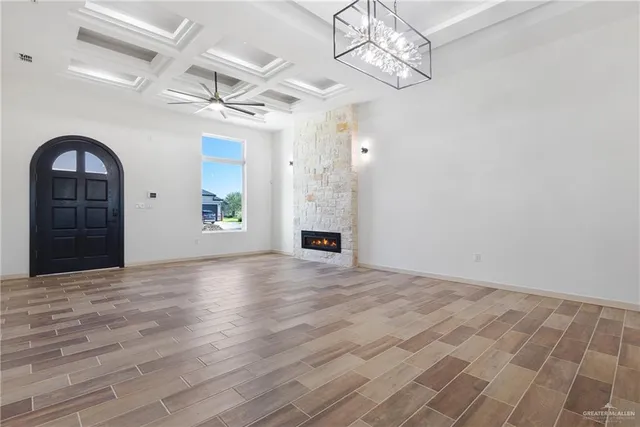 a view of an empty room with a fireplace and wooden floor