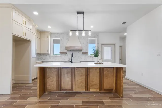 a large kitchen with granite countertop a sink and cabinets
