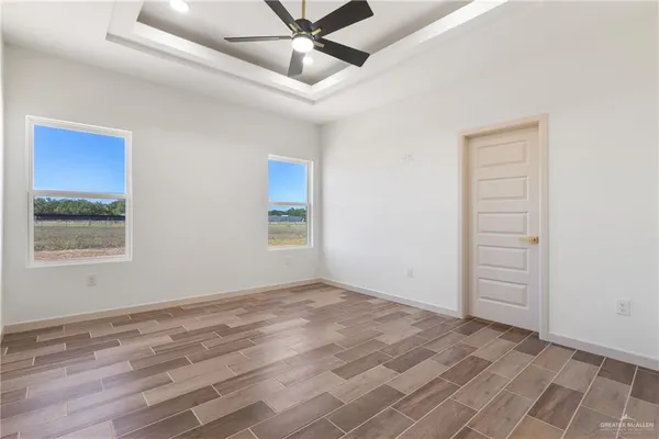 an empty room with a ceiling fan and window