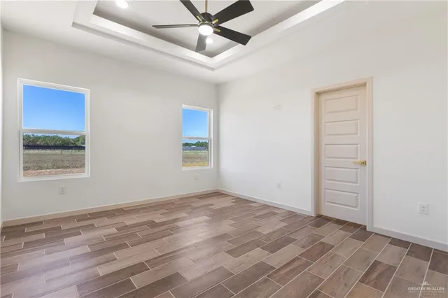 an empty room with a ceiling fan and window