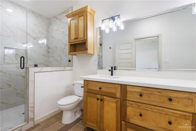 a bathroom with a toilet a sink a mirror a and a shower