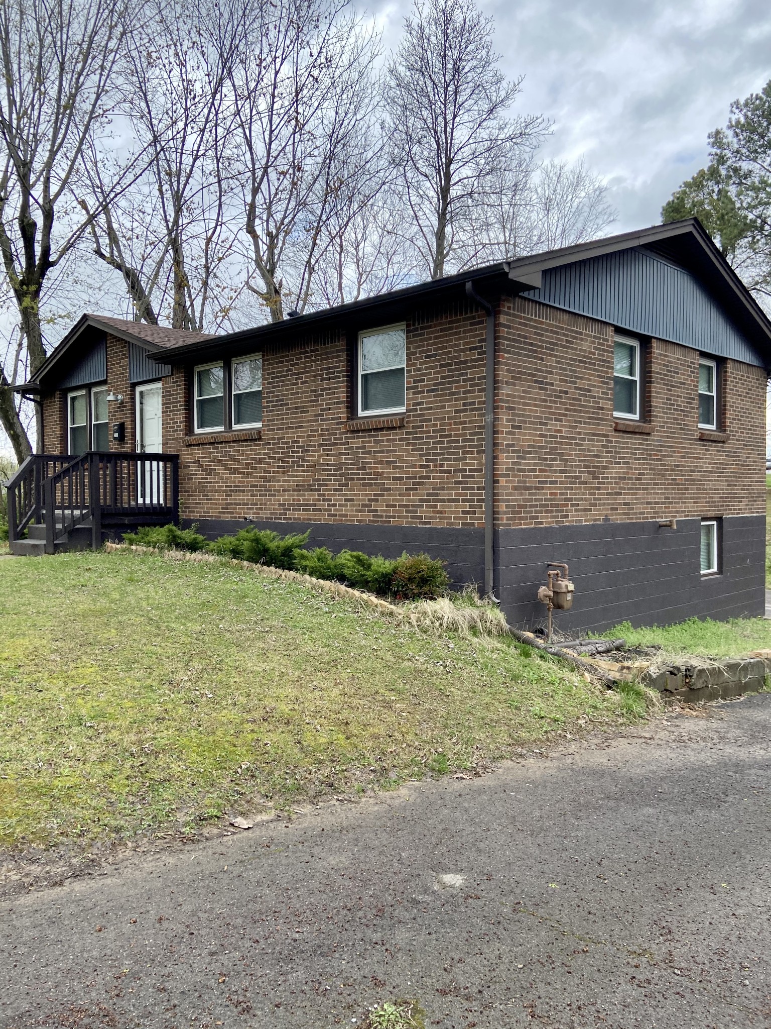 211 Pitt Lane Springfield, TN 37172 - Photo 3 of 18 a brick house with a yard plants and large tree