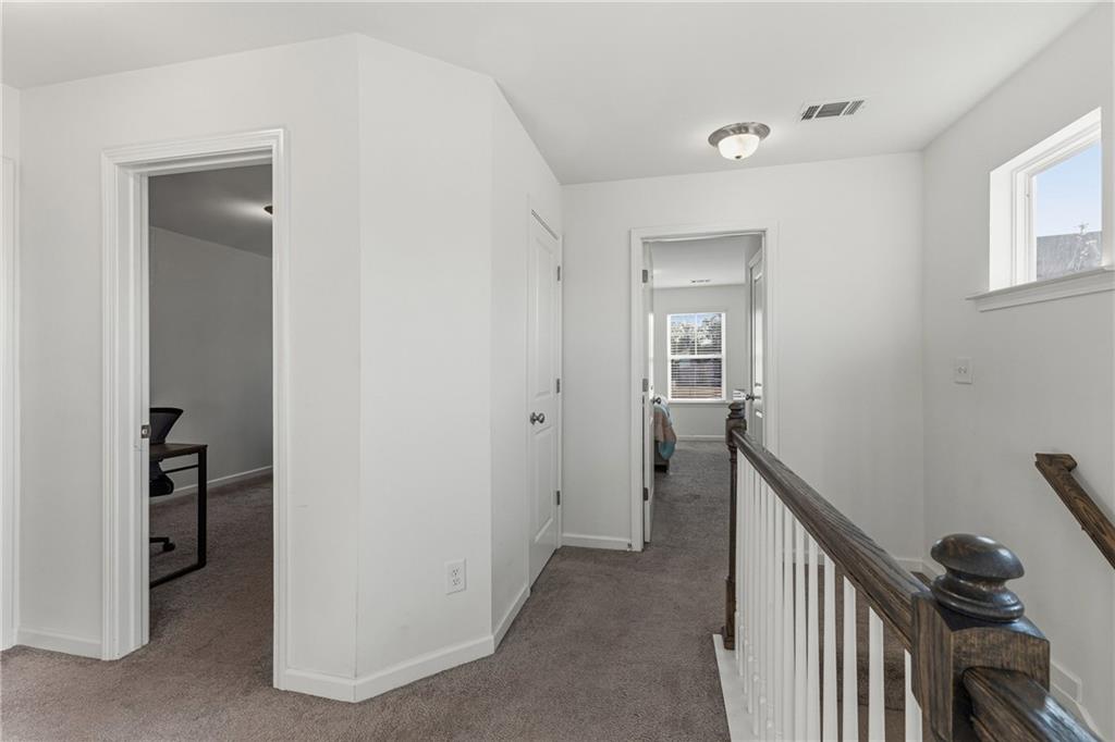 2275 Rolling Trail Lithonia, GA 30058 - Photo 24 of 38 a view of a hallway to a livingroom with wooden floor and stairs