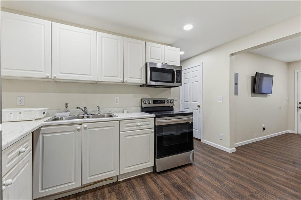 2275 Rolling Trail Lithonia, GA 30058 - Photo 28 of 38 a kitchen with stainless steel appliances granite countertop a stove a sink and a microwave