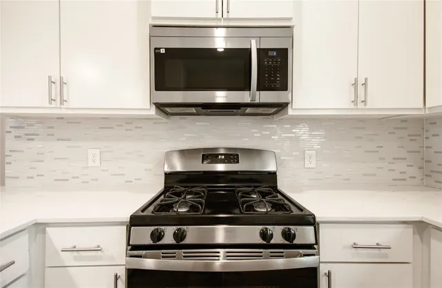 a stove top oven sitting inside of a kitchen