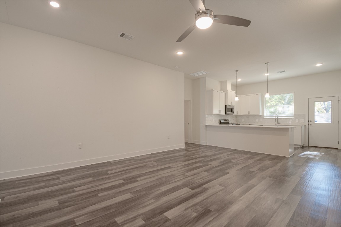 6325 Ponca Street, Unit A Austin, TX 78741 - Photo 6 of 21 an empty room with wooden floor and kitchen view