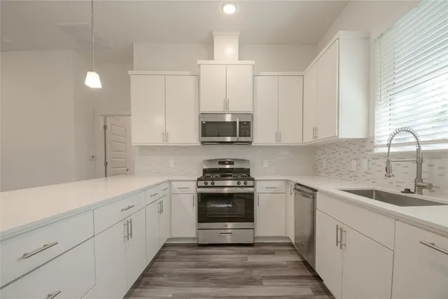 a kitchen with stainless steel appliances granite countertop a sink stove and refrigerator